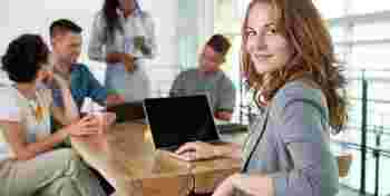 Image of a succesful casual business woman using laptop during meeting