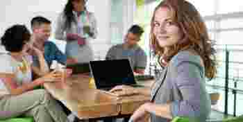 Image of a succesful casual business woman using laptop during meeting