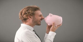 Handsome man with piggy bank on grey background Handsome man with piggy bank on grey background
